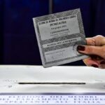 Un'elettrice inserisce la scheda nell'urna in un seggio italiano alle europee 2024