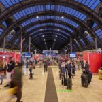 Viaggiatori con valigie e trolley sui binari della stazione di Milano Centrale